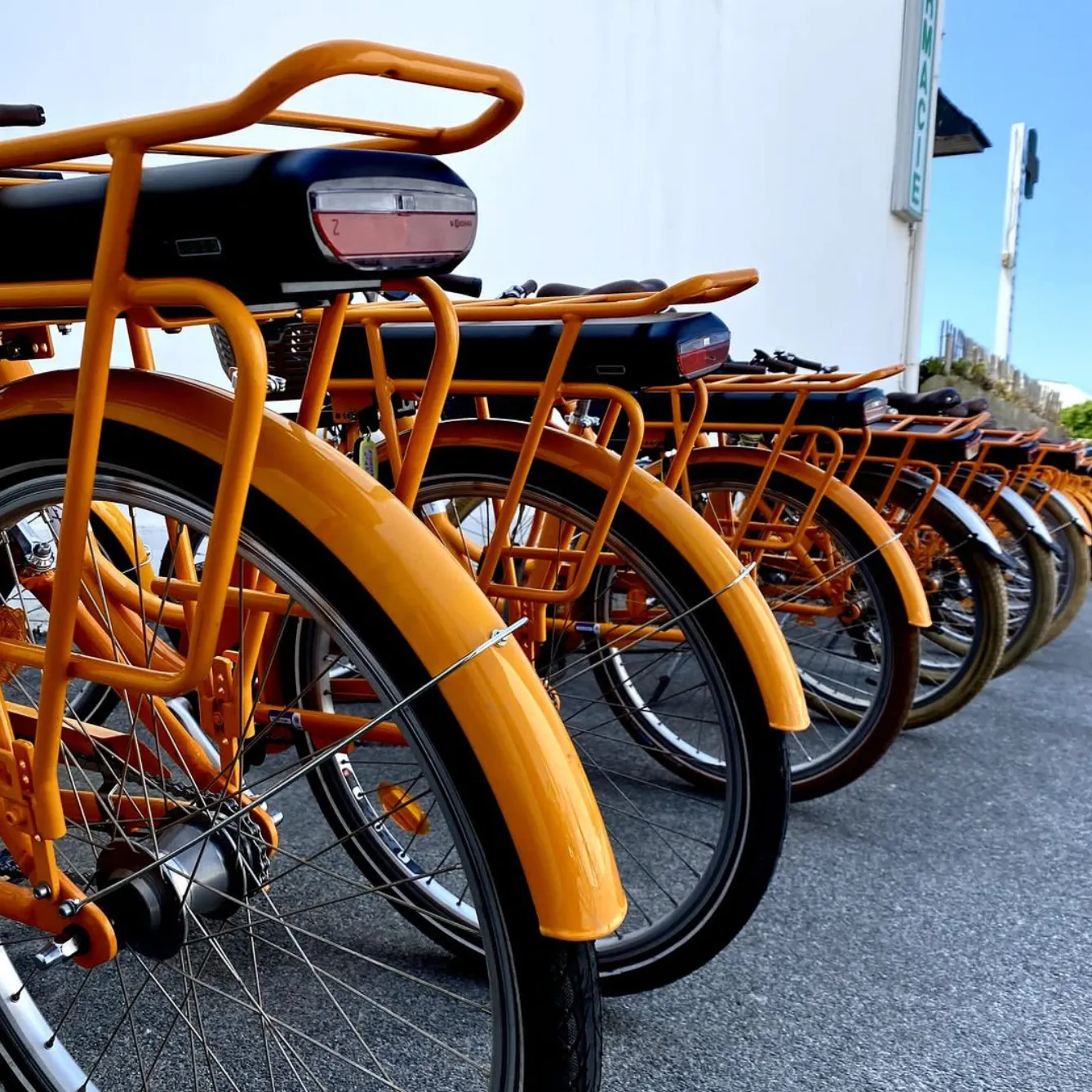 La flotte de vélos orange des Frères Complices alignée devant la point de location de Porspoder
